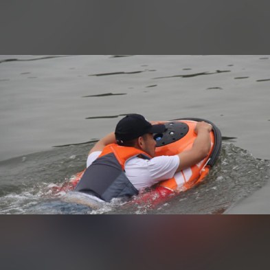 Person in the water holding on to the Remote Controlled Lifebuoy